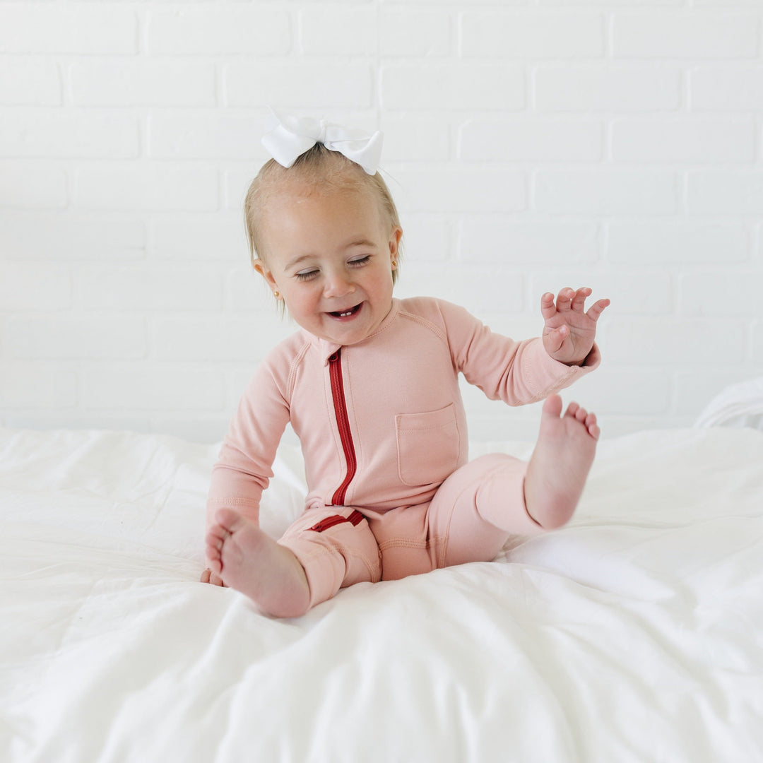Baby wearing Our Little Treasures organic cotton zip romper in Cotton Candy